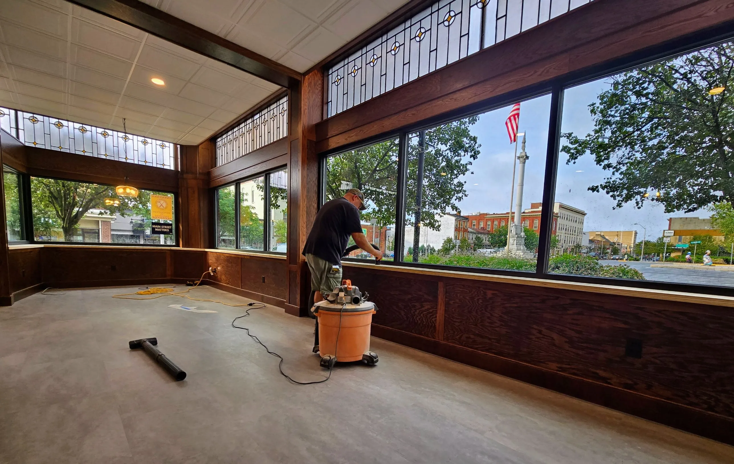 A restored storefront with oak paneling and leaded-glass transoms overlooking Monument Square